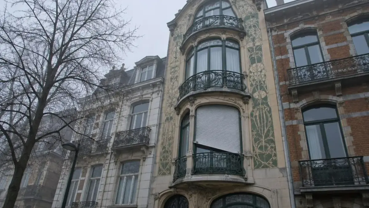 Haute façade Art nouveau à Saint-Gilles, volet roulant blanc bloqué en biais au premier étage