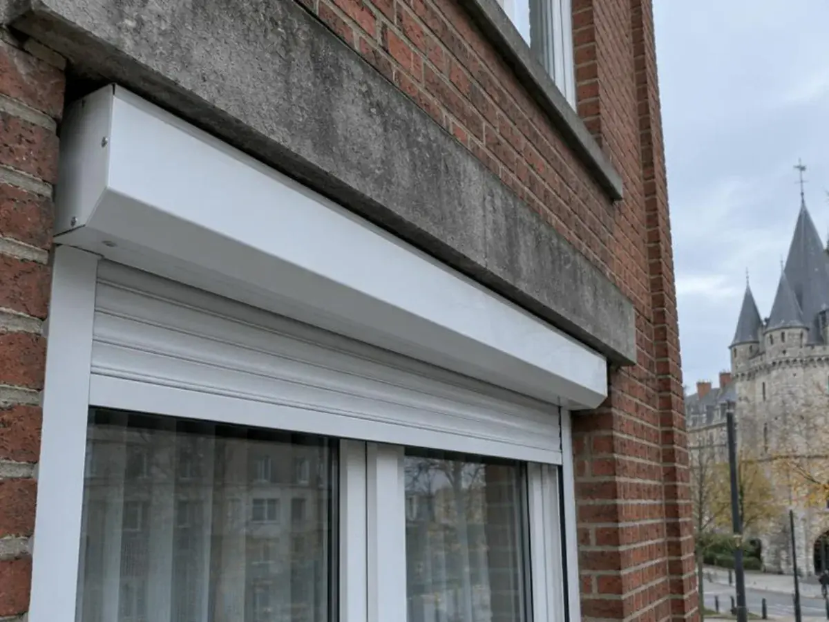 Coffre extérieur blanc posé sous le linteau en pierre d'un appartement près de la Porte de Hal